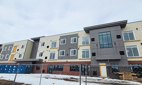 a row of apartments with a rainbow on the side of them
