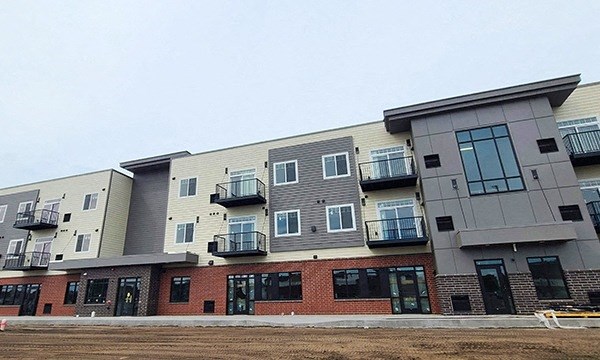 a new apartment building with balconies and a dirt field