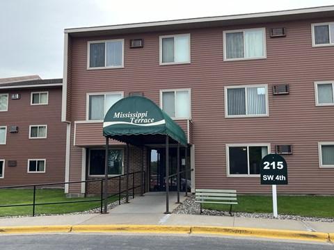 The front of the Mississippi Terrace apartment building with a green awning.