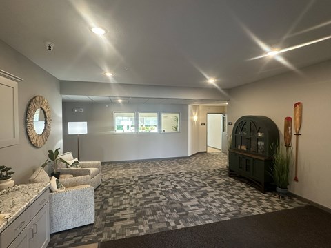 A spacious room with a grey carpet and a mirror on the wall.