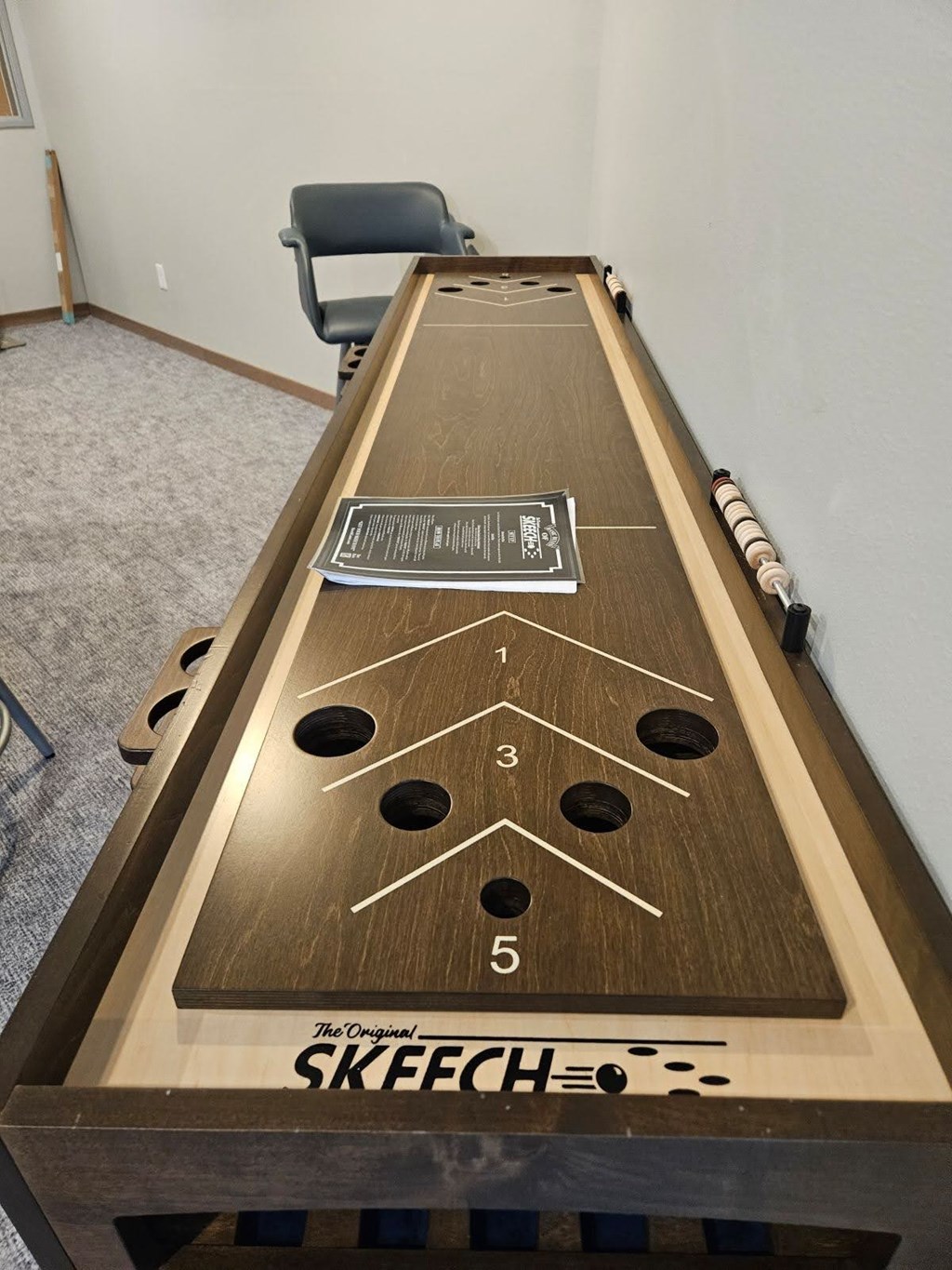 A shuffleboard table with the word SKEECH on it.