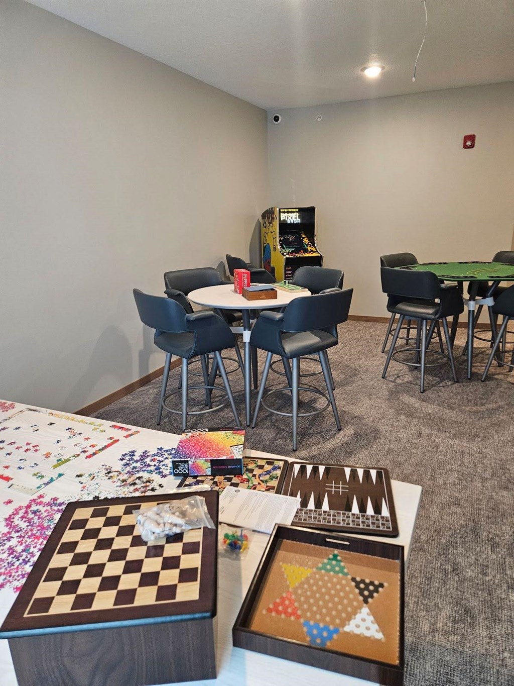A room with a table, chairs, and a checkerboard on the table.
