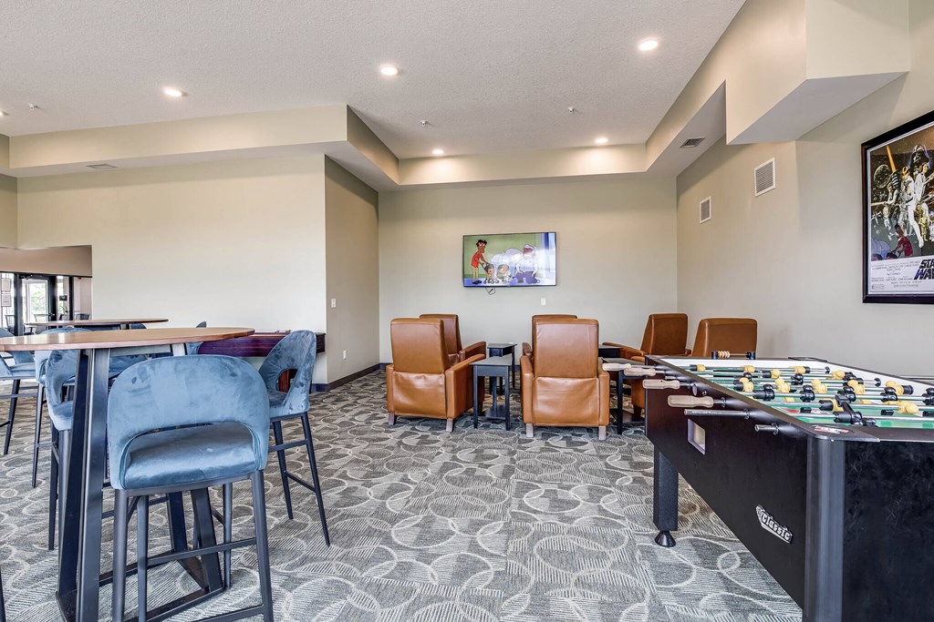 a game room with a foosball table and chairs and a table top game