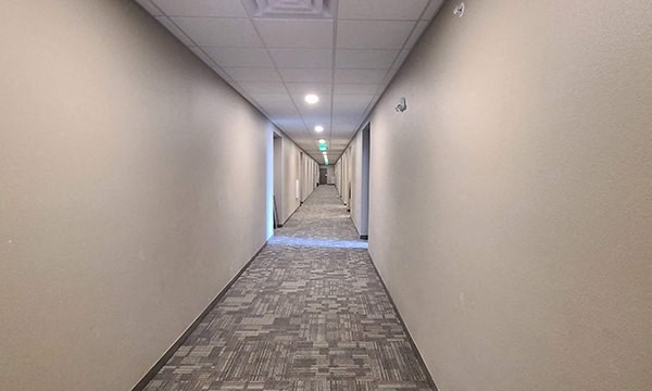a long hallway with white walls and a tile floor