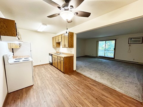 A kitchen with wooden floors and a white refrigerator.