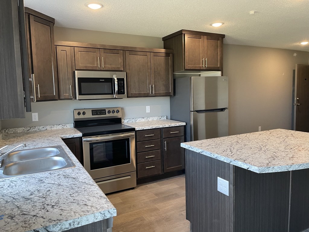 a kitchen with granite counter tops and stainless steel appliances