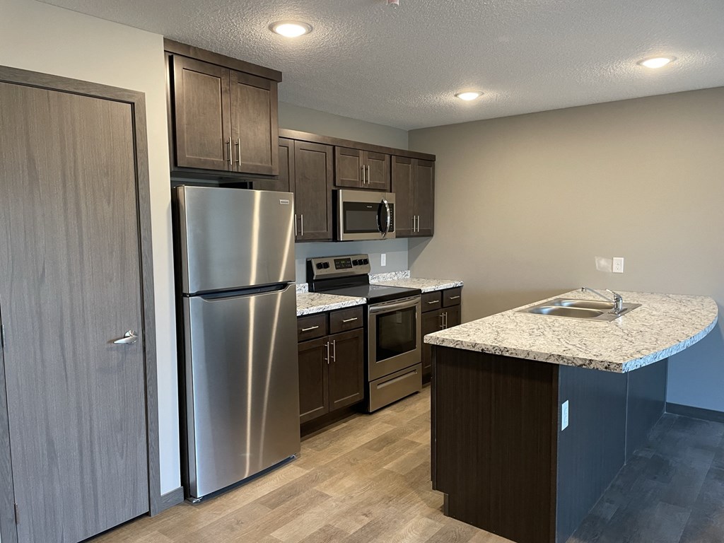 a kitchen with stainless steel appliances and a marble counter top