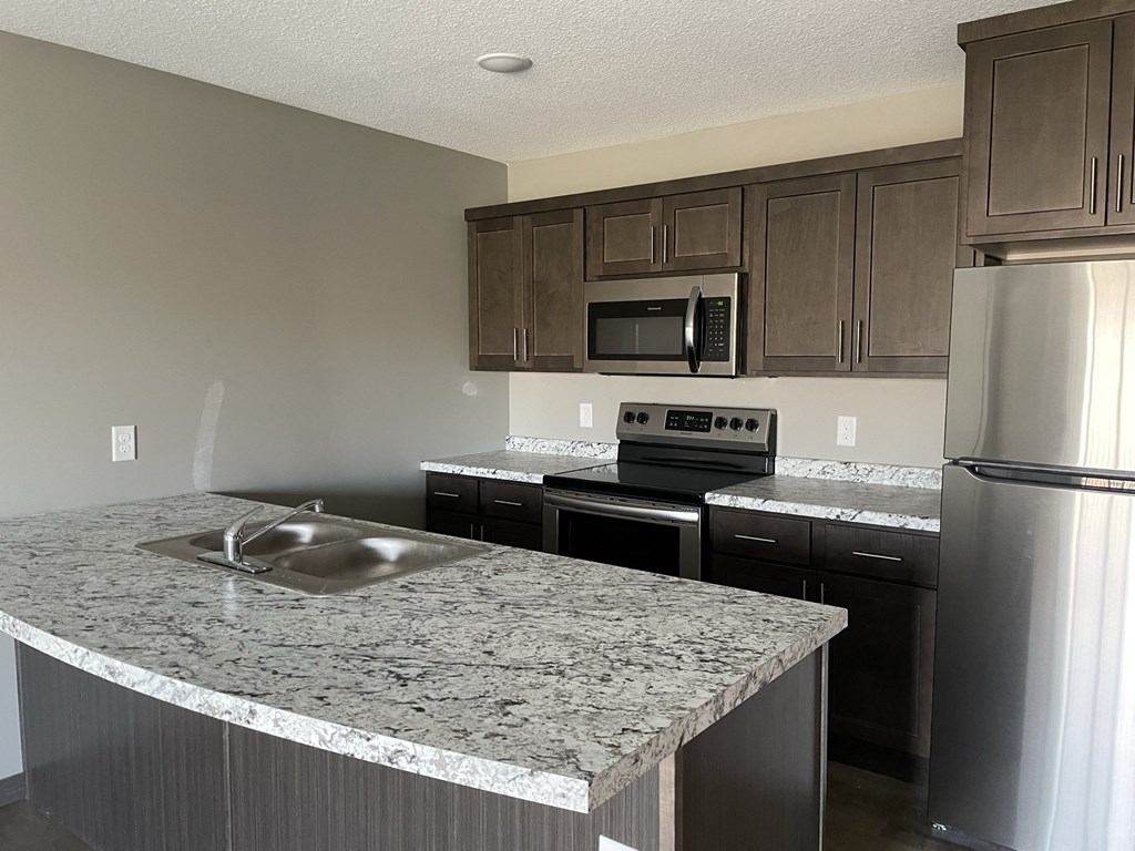 a kitchen with granite counter tops and stainless steel appliances