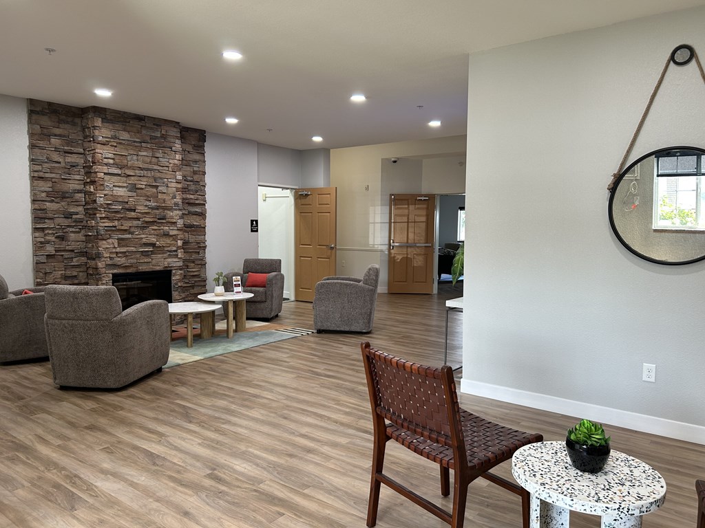 A living room with a stone fireplace and a wooden chair.