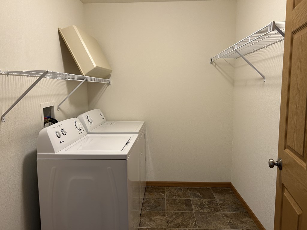 A small laundry room with a washer and dryer.