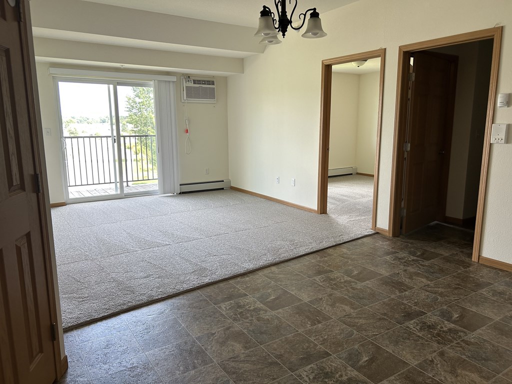 A room with a sliding glass door and a tiled floor.