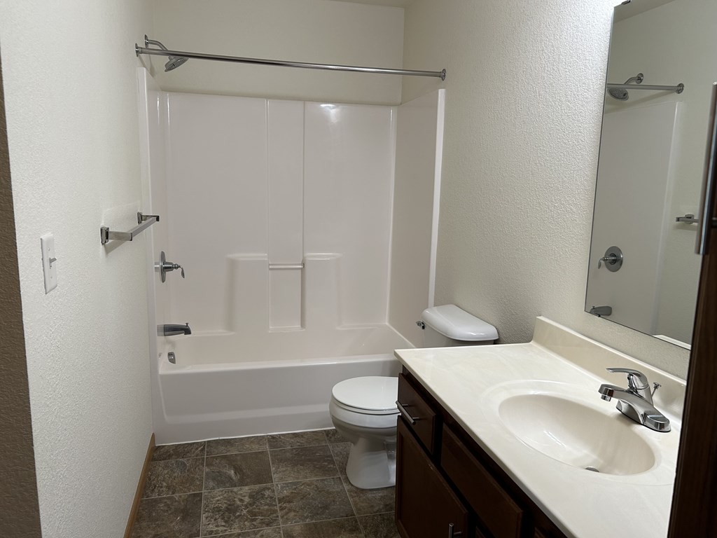 A white bathroom with a toilet, sink, and bathtub.