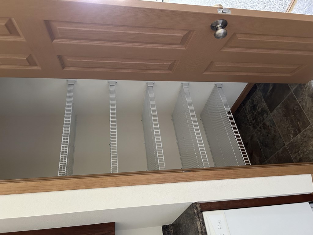 A wooden ceiling with a white wall and a brown door.