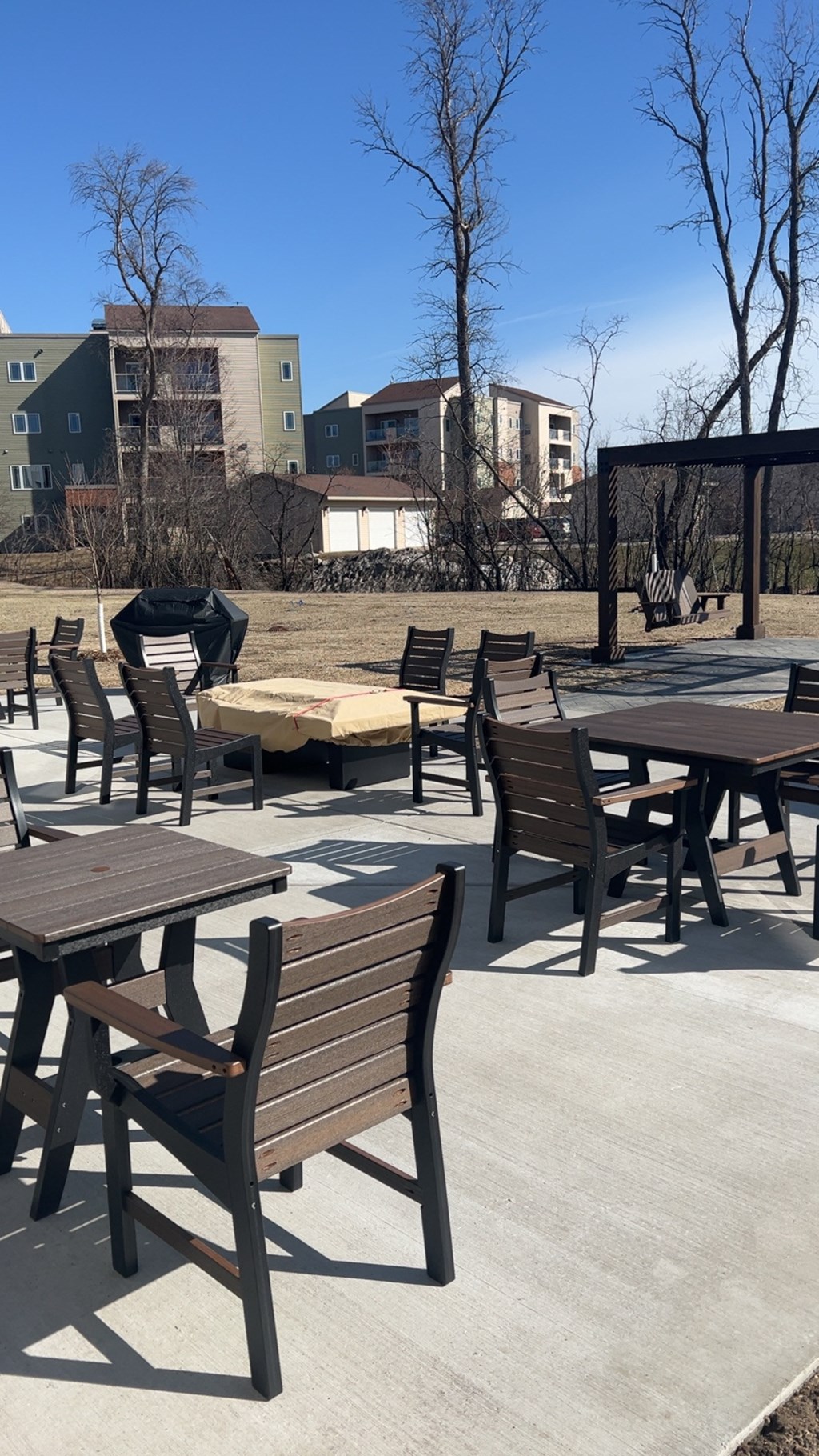 A patio with tables and chairs is empty.