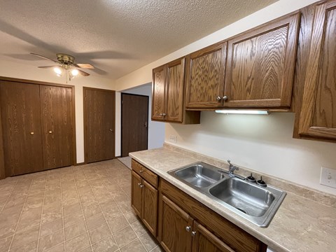 A kitchen with brown cabinets and a tile floor.
