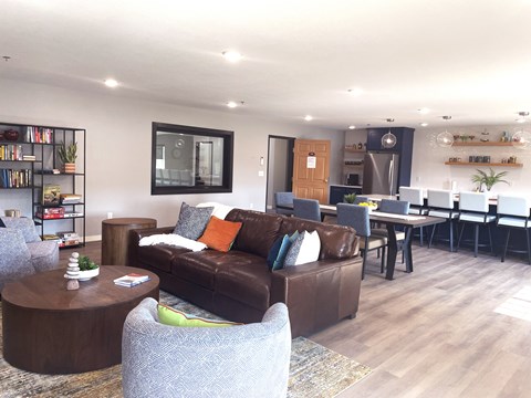 A modern living room with a brown couch and a grey armchair.