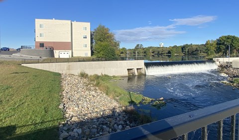 a waterfall in a river with a building in the background
