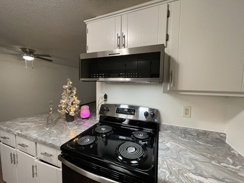 A black stove top oven in a kitchen with a pink light on.