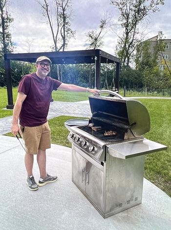 A man is grilling food on a portable stove.
