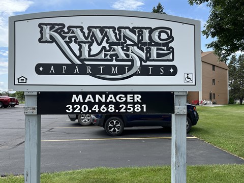 A sign for Kawanico Apartments with a phone number for the manager.