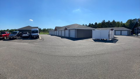 A parking lot with several cars and a few buildings in the background.