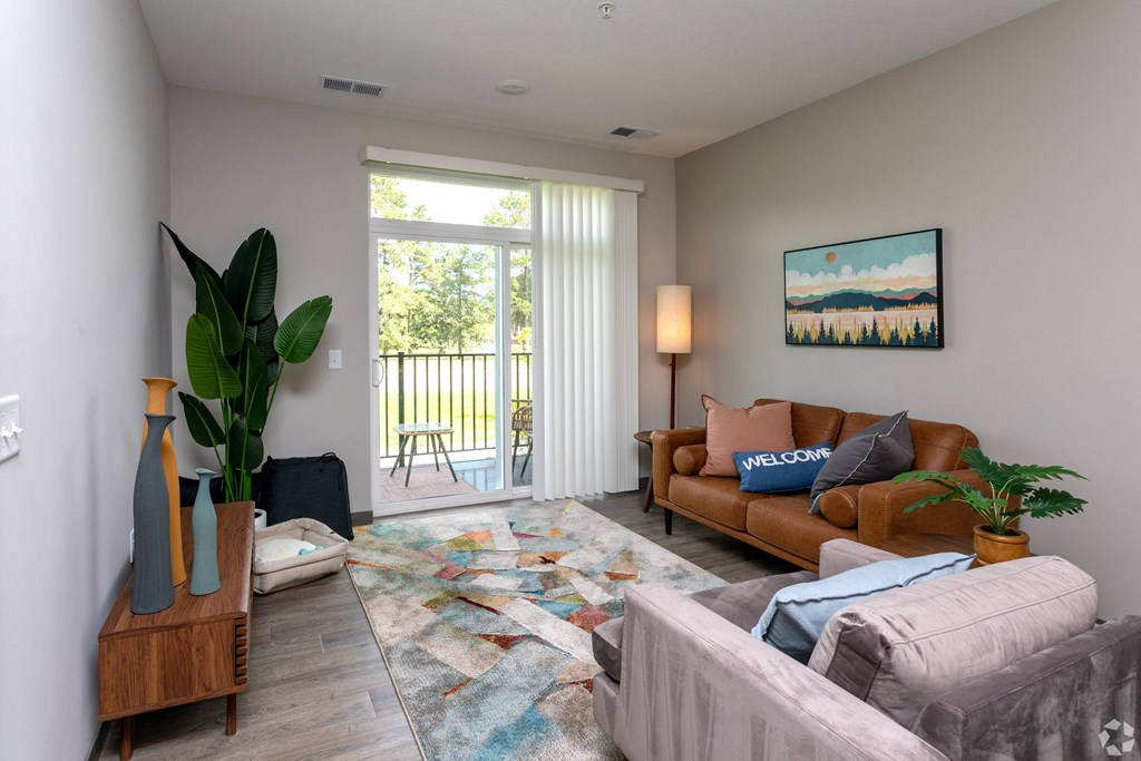 a living room with a couch and a chair and a sliding glass door
