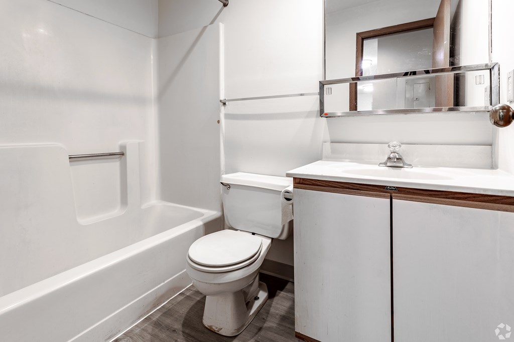 BLDG B/D - A white toilet sits in a bathroom next to a sink.