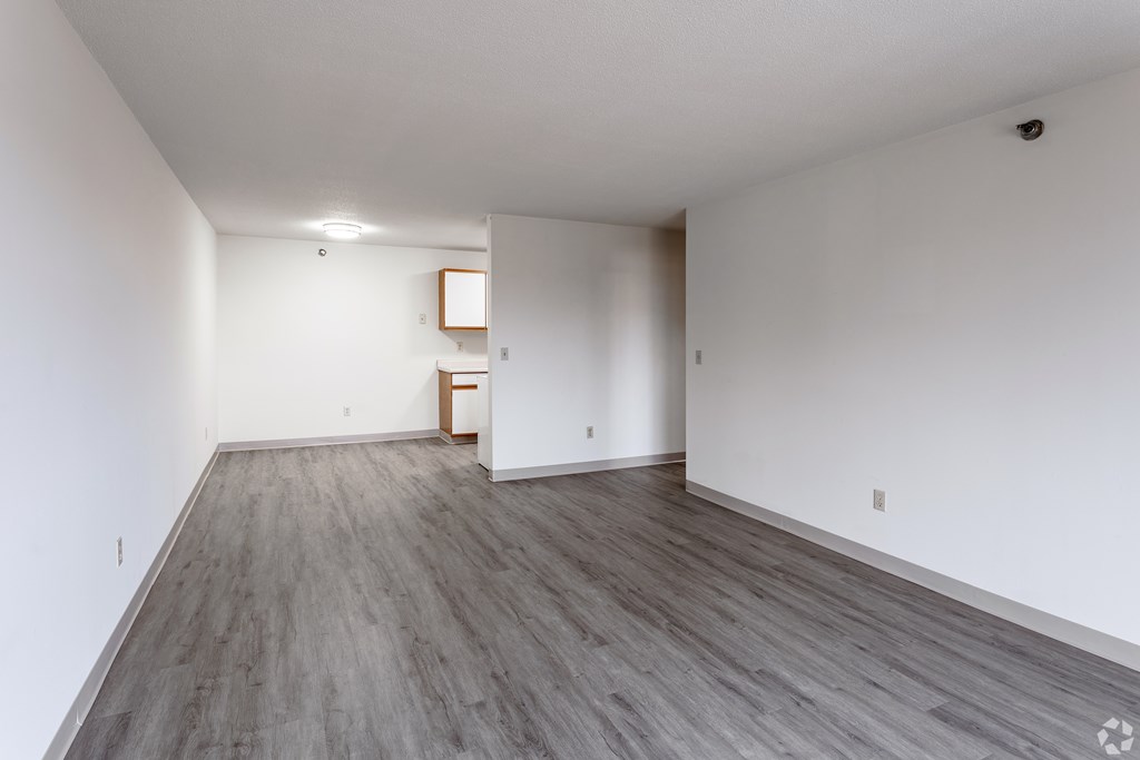 BLDG B/D - A room with wooden flooring and white walls.