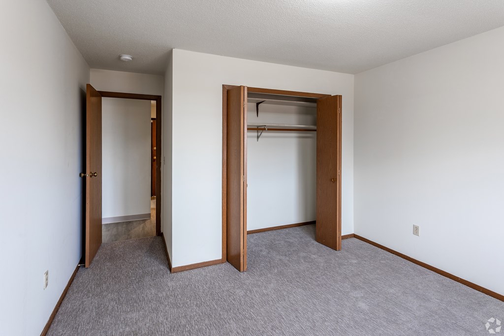 BLDG B/D - A room with a carpeted floor and two open doors.