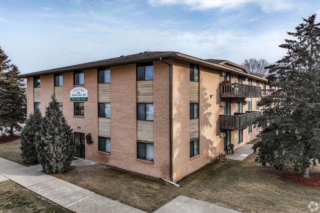 BLDG D - A brick apartment building with a balcony on the second floor.
