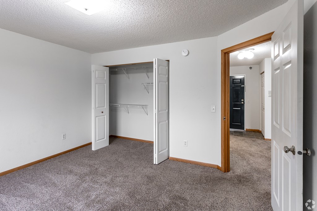 BLDG A/C - A room with a white door and a grey carpet.