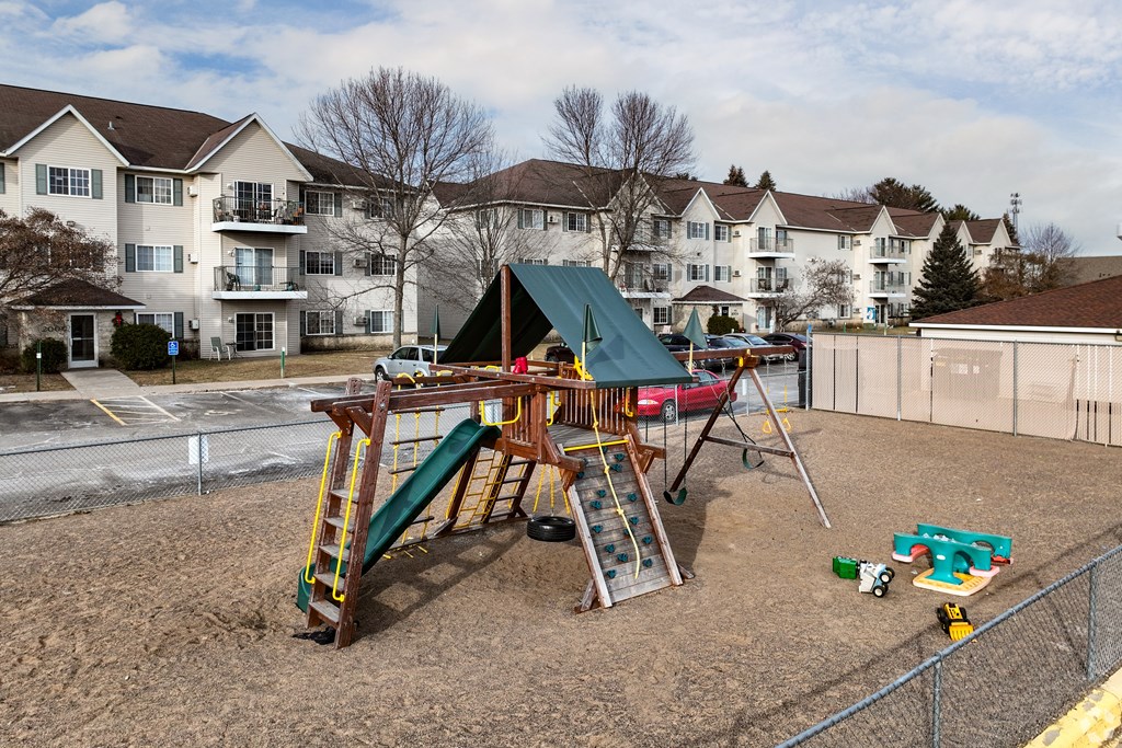 BLDG A/C - A playground with a green slide and a red car.