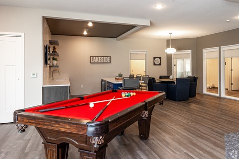 A pool table in a room with a sign that says "Lakeside.".