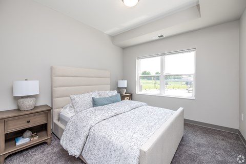 A bedroom with a large bed and a window overlooking a parking lot.