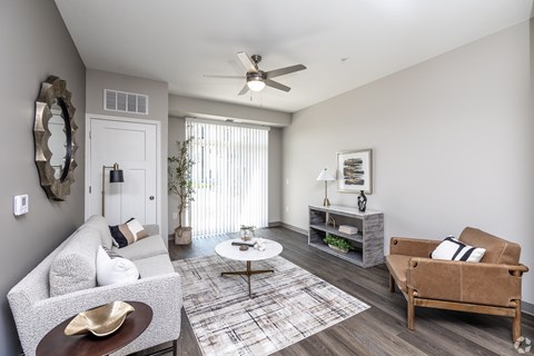 A living room with a grey couch, a coffee table, and a brown armchair.