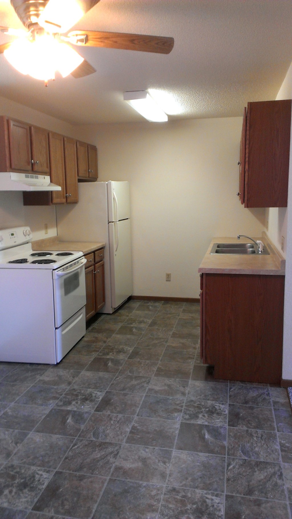 A kitchen with a white stove and white refrigerator.
