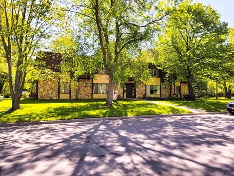 A house with a driveway and trees in front of it.