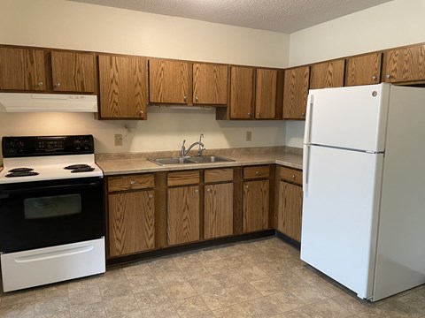 A kitchen with wooden cabinets and a white refrigerator.