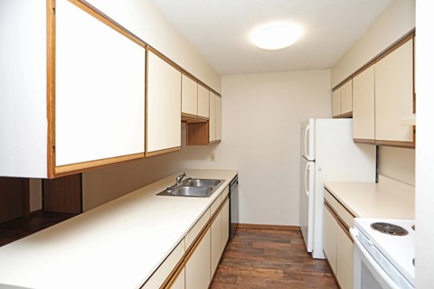 A kitchen with white appliances and wooden cabinets.