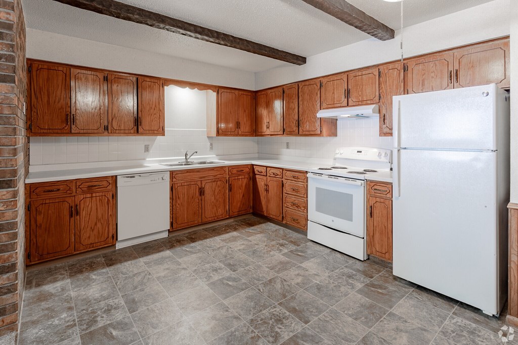 A kitchen with wooden cabinets and white appliances.