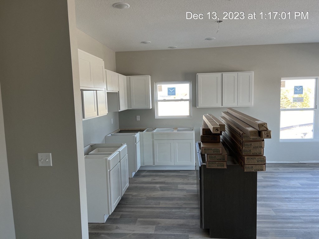 an empty kitchen with white cabinets and counters and white appliances