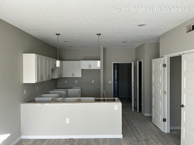 an empty kitchen with white cabinets and a counter top