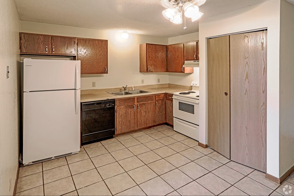 A kitchen with a white refrigerator and wooden cabinets.