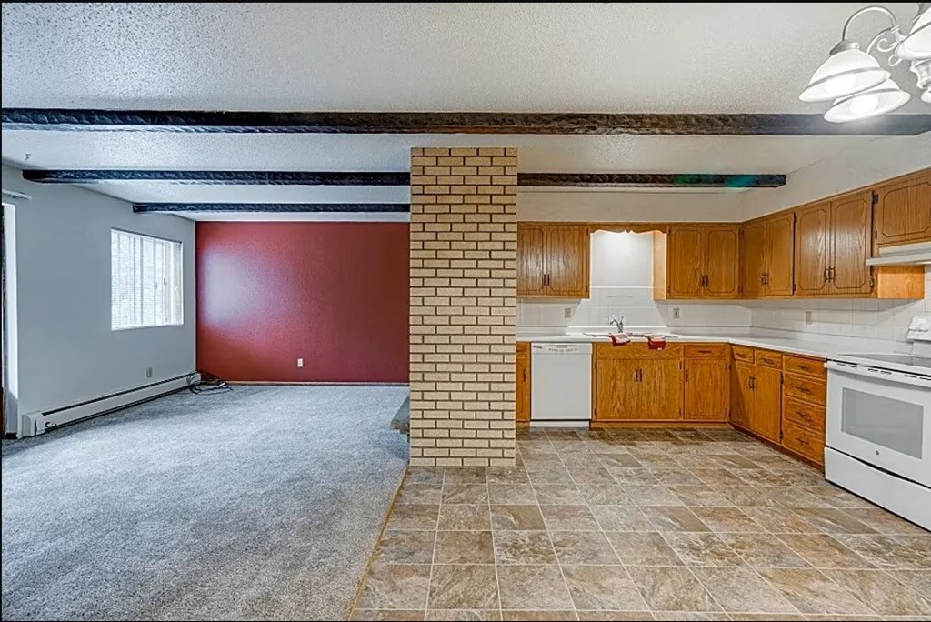 A kitchen with wooden cabinets and a tiled floor.