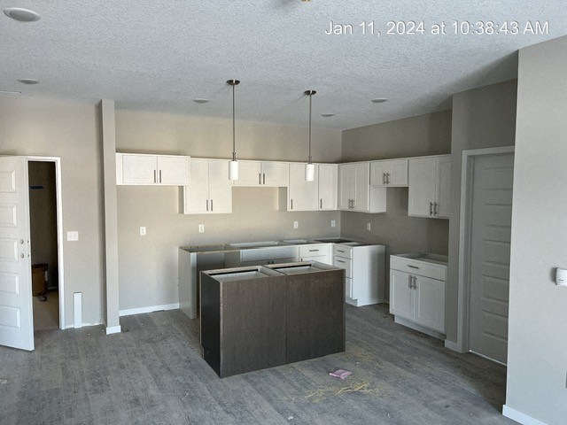 an empty kitchen with an island and white cabinets