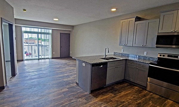 an empty kitchen and living room with a sliding glass door