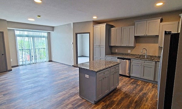 a kitchen with an island in the middle of a living room