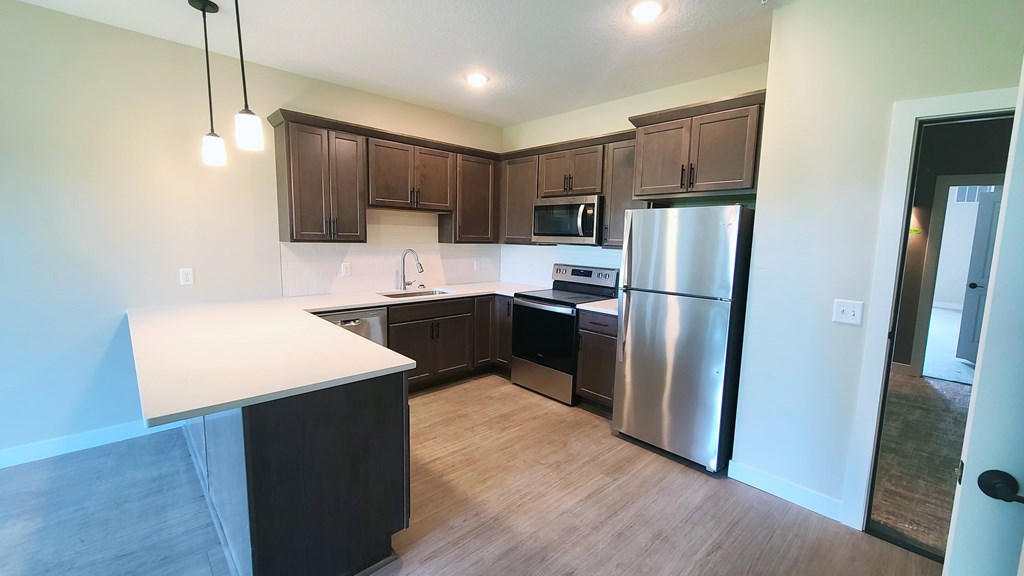 a kitchen with stainless steel appliances and dark wood cabinets