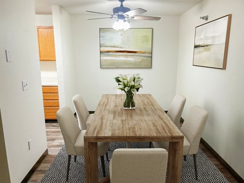 A dining room with a wooden table and chairs.