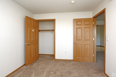 A room with two doors and a carpeted floor.